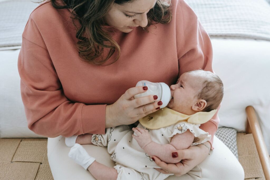 woman bottle feeding baby